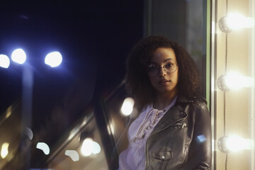 Fashionable woman on urban city street at night