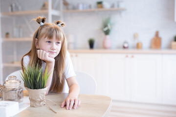 Obraz premium concept of children in the kitchen. Adorable little girl in a white T-shirt.