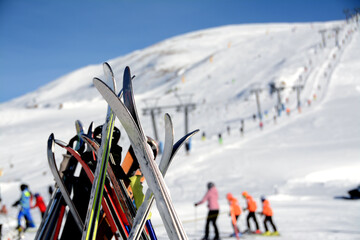  ski equipment on blurred background of skiers, snow, slopes, ski lift in the alpine sun of...