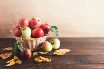 Basket of apples on a wooden table. Autumn harvest. Copy space.