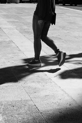 Girl walking with elongated shadow in black and white.Black and white. Shadow and light, girl silhouette