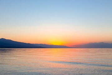 Obraz premium Dawn of the sun at sea. The rising sun behind the mountains. Kyrgyzstan.
