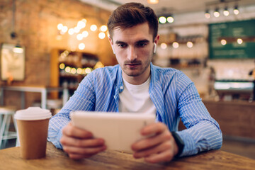 Concentrated man with smartphone at table in cafe