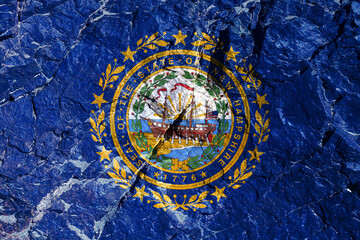 USA flag of New Hampshire with seal in center with a frigate flanked by laurel branches separated by nine stars. Raleigh is one of first warships for Navy. Rock graffiti of climbers during the ascent.