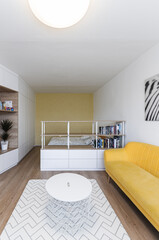 White modern minimalistic living room with yellow sofa conected with bedroom