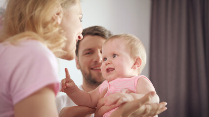Mother shaking head for baby. Joyful family have fun. Cute infant smile to mom