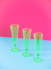 Plastic glasses isolated on blue and pink background