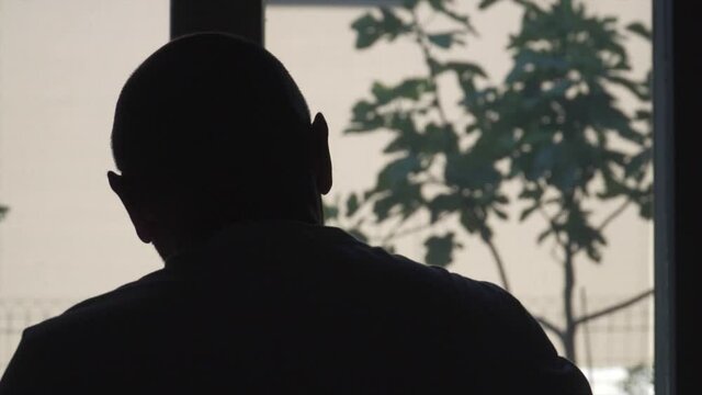 silhouette of a bald man working