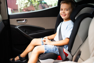 A boy sitting in car seat locked with safety belts