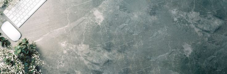 White computer keyboard, mouse, gypsophila flowers, eucalyptus flowers on marble background. Top view. Copy space. Flat lay. Feminine workspace. Blogger, business concept. Mock up. Birthday