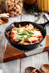 Chicken with tomatoes and cheese in cast iron pan