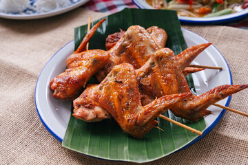 Roasted chicken on stick on banana leaf.