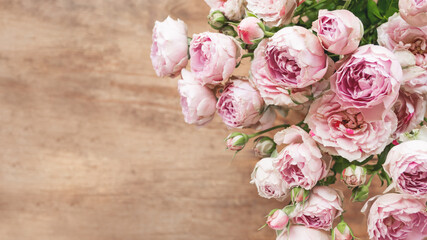 Bouquet of lilac colored roses upon wooden background. Top view, flat lay. Still life banner with copy space.