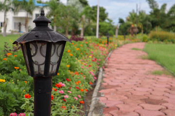 Beautiful lamp post to light up walkway in a garden with colorful flowers.