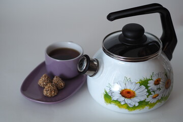 The kettle is enamelled, with a whistle, white. Close-up. 