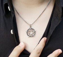 pentagram pendant on the chest of a woman. ring on male finger. close up image. In Freemasonry, the...