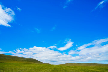 Aerial shooting in the mountains with a drone. View of the green valley, blue sky with beautiful...