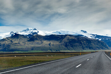 Fototapeta premium Road in Iceland with mountains and snow in the background