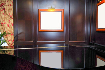 Reflection of picture frames on high gloss surface of piano in lounge or bar of luxury cruiseship...