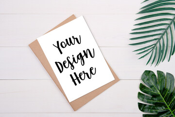 Blank paper sheet copy space with mockup and leaf on wooden table, poster and notebook, postcard decoration your design or branding, simplicity and minimal, nobody, flat lay, top view.