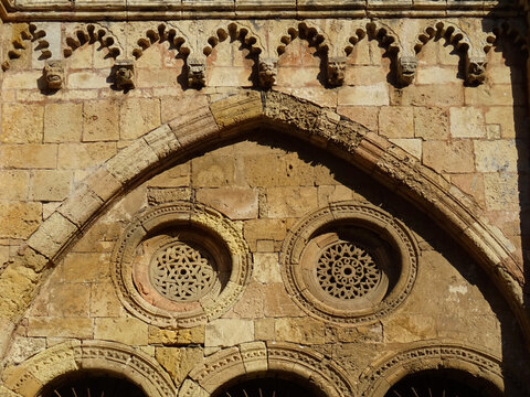 Cathedral of Tarragona. Spain. 12-13 century. 
Detail of the cloister. Cornice decorated with multifoil arches, brackets with heads and lattice in the rose window.  