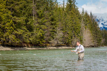 Fototapeta na wymiar Close up of a fisherman spey casting on a river in British Columbia, Canada