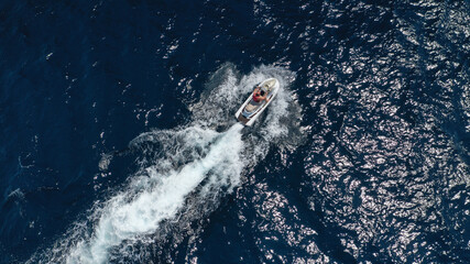 Obraz premium Aerial photo of woman operating jet ski cruising in low speed in deep blue crystal clear waters