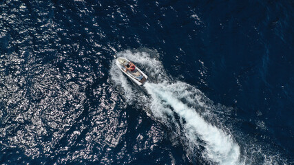Obraz premium Aerial photo of woman operating jet ski cruising in low speed in deep blue crystal clear waters