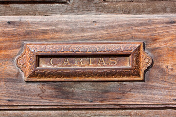 Vintage colonial mailbox on the aged wooden door, horizontal composition, Antigua, Guatemala