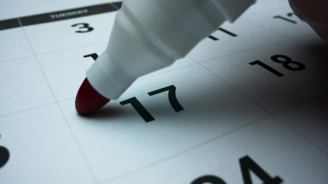 Business calendar for event planning. Female hand marking date on calendar