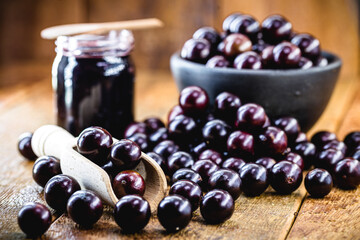 Brazilian grape jam, on a rustic wooden table. Jabuticaba, exotic fruit from Brazil, used in cooking as a sweet.