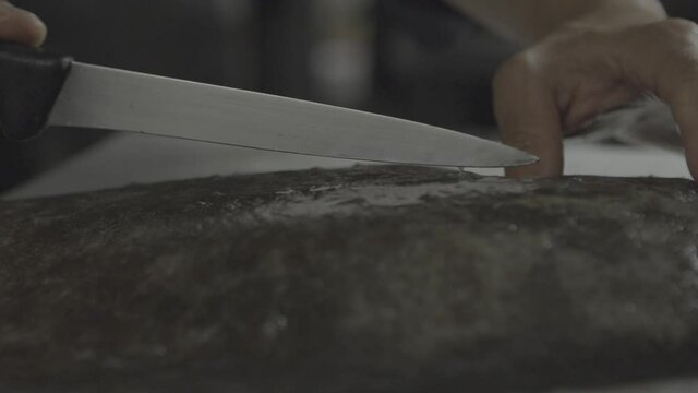 A chef slice a fresh fish in a gastronomic restaurant 