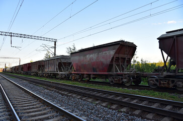 Obraz premium Hopper wagons and rail road cars for transportation of cement, ready-mix and building materials. Shipping by rail from the concrete factory. Freight cars, hopper car for sand or mineral products