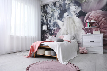 Teenage girl's room interior with comfortable bed and floral wallpaper. Idea for stylish design © New Africa