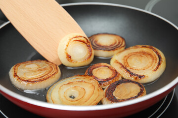 Cooking onion rings in frying pan, closeup