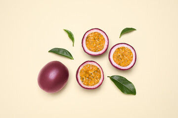 Fresh ripe passion fruits (maracuyas) with leaves on beige background, flat lay