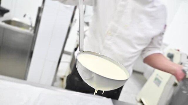 Pastry chef using a ladle pouring cream. High quality FullHD footage
