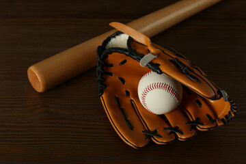 Leather baseball ball, bat and glove on wooden table
