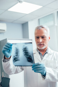 Confident mature man with x-ray slide in hands