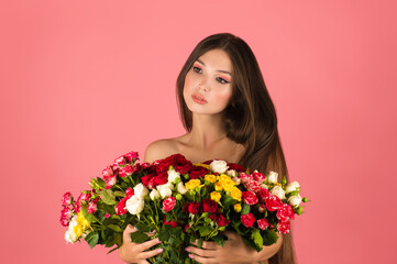 young beautiful woman with flowers isolated on pink background
