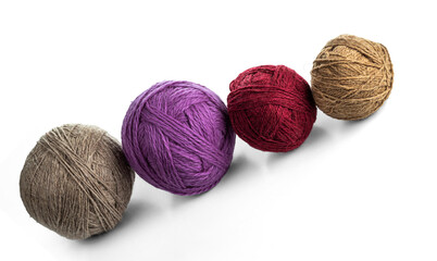 Balls of yarn in different colors on a white inclined plane.