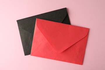 Colorful paper envelopes on pink background, top view