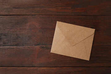 Brown paper envelope on wooden table, top view. Space for text