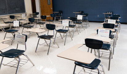 Empty classroom with signs to leave desks empty for social distance to return to school