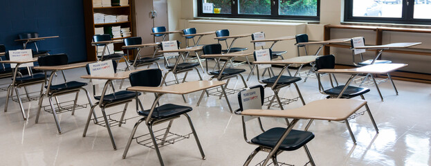 High school classroom ready for students to return with signs on chairs not to be used