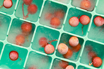 Berries frozen in ice cubes. Ice in a silicone mold for the freezer close-up