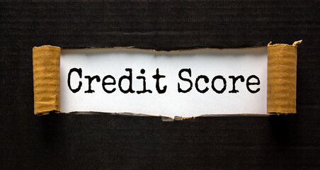 The text 'credit score' appearing behind torn black paper. Business concept.