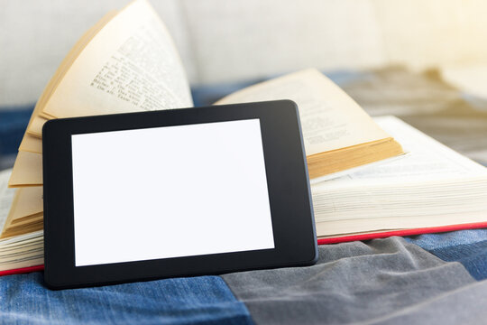 e-book concept of reading e-books. Book reader next to paper books.