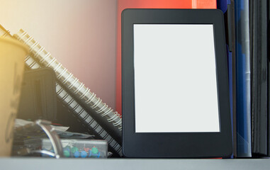 e-book concept of reading e-books. Book reader next to paper books.