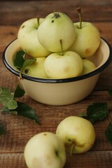 Delicious green apples with leaves on the table